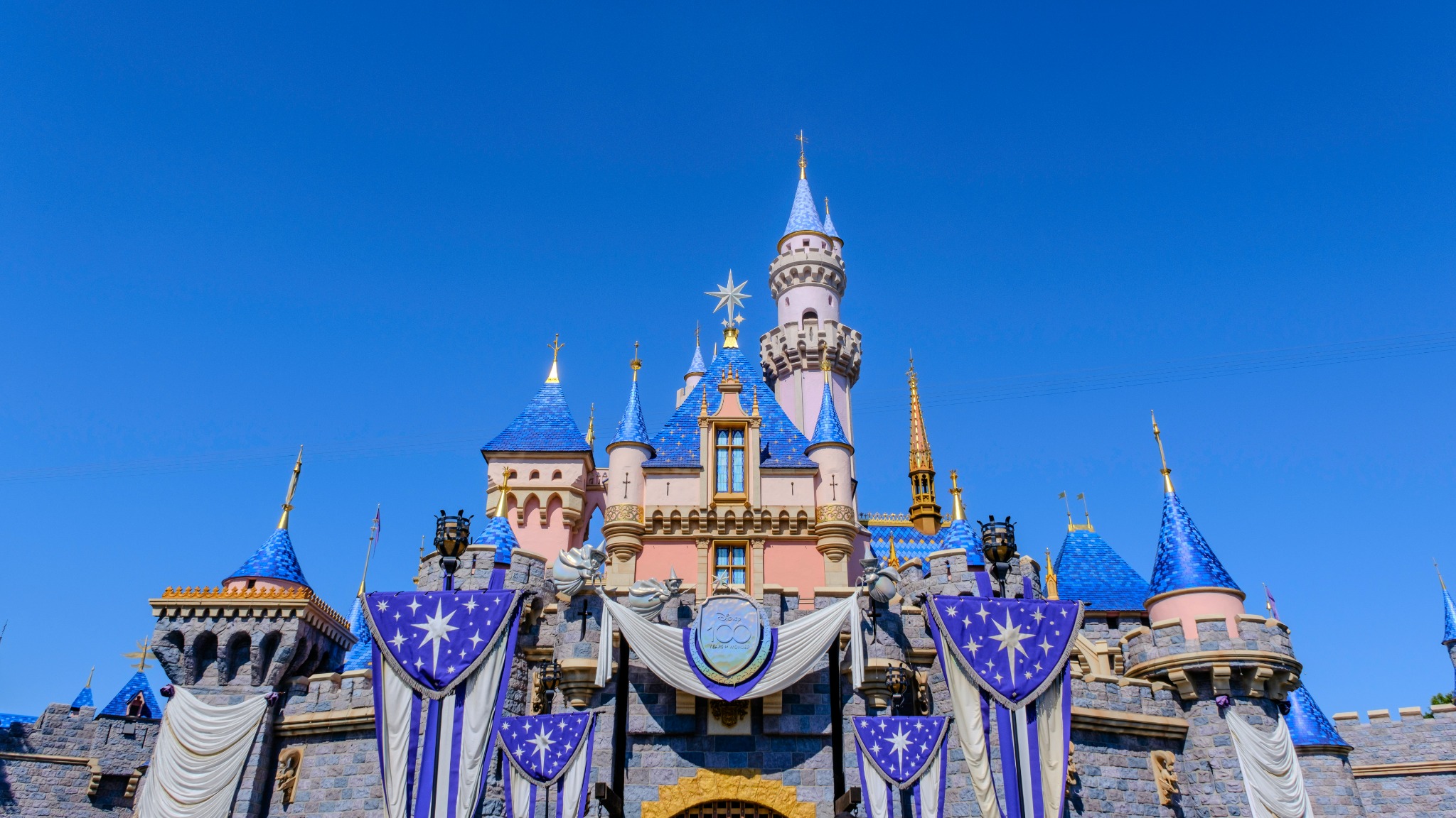 Sleeping Beauty Castle at Disneyland decorated for the Disney100 celebration