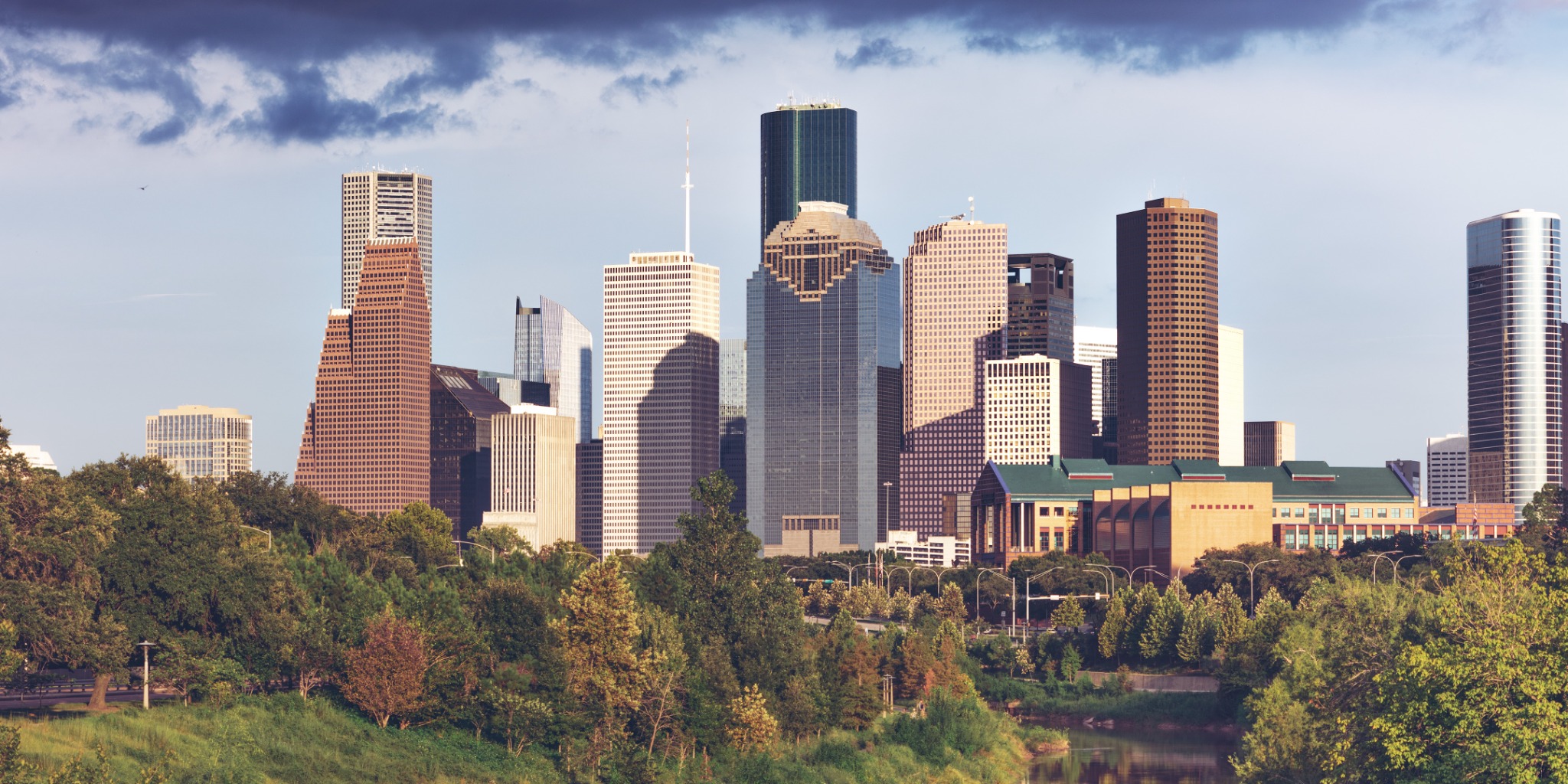 Downtown Houston skyline viewed across Buffalo Bayou and green parkland