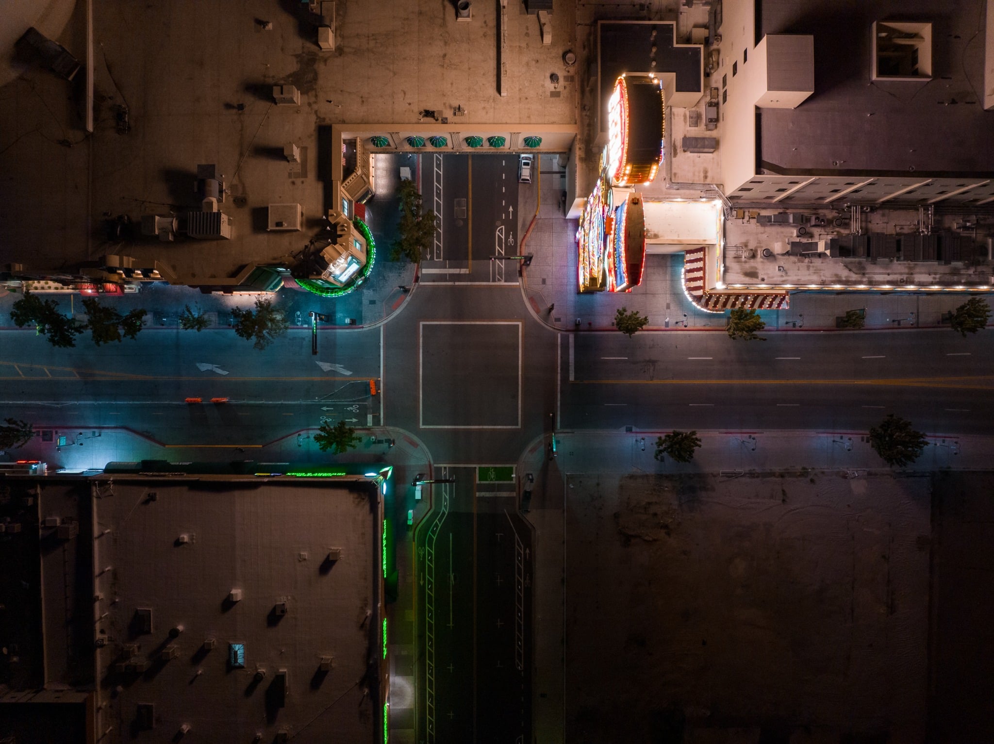 Top-down aerial night view of a downtown Reno intersection surrounded by neon-lit casino buildings.
