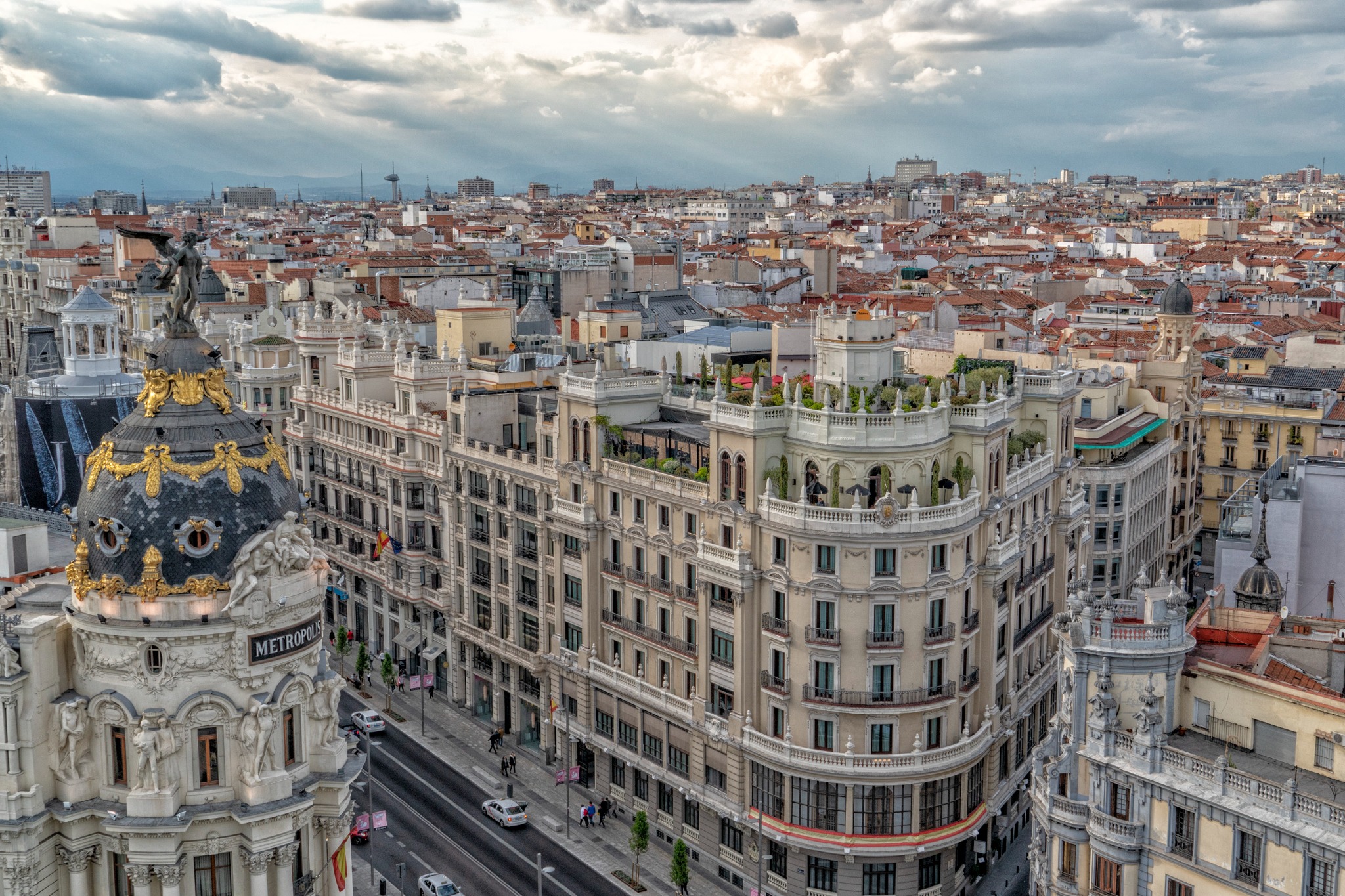 Aerial cityscape of Gran Via in Madrid with the Metropolis Building and historic rooftops.