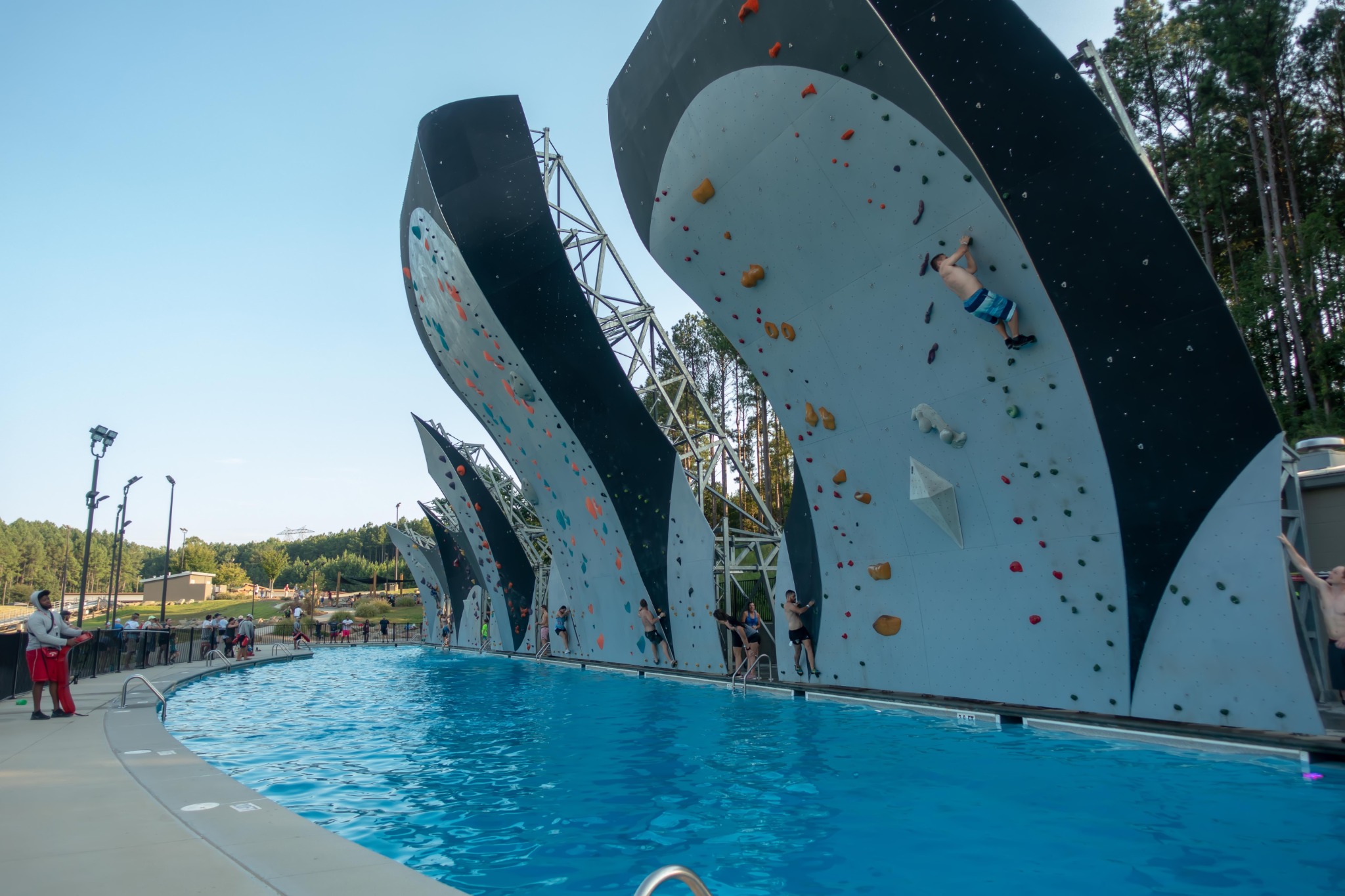 Outdoor climbing walls rising above a swimming pool during a rock climbing event in Reno, Nevada.