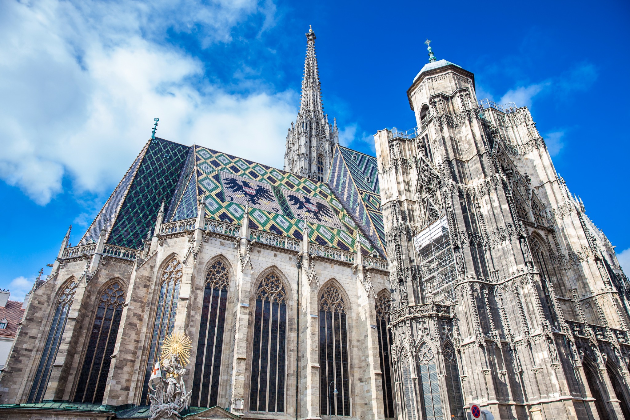 Exterior view of St. Stephen’s Cathedral, or Stephansdom, in Vienna, Austria, highlighting its Gothic stonework, tall south tower and distinctive patterned roof.