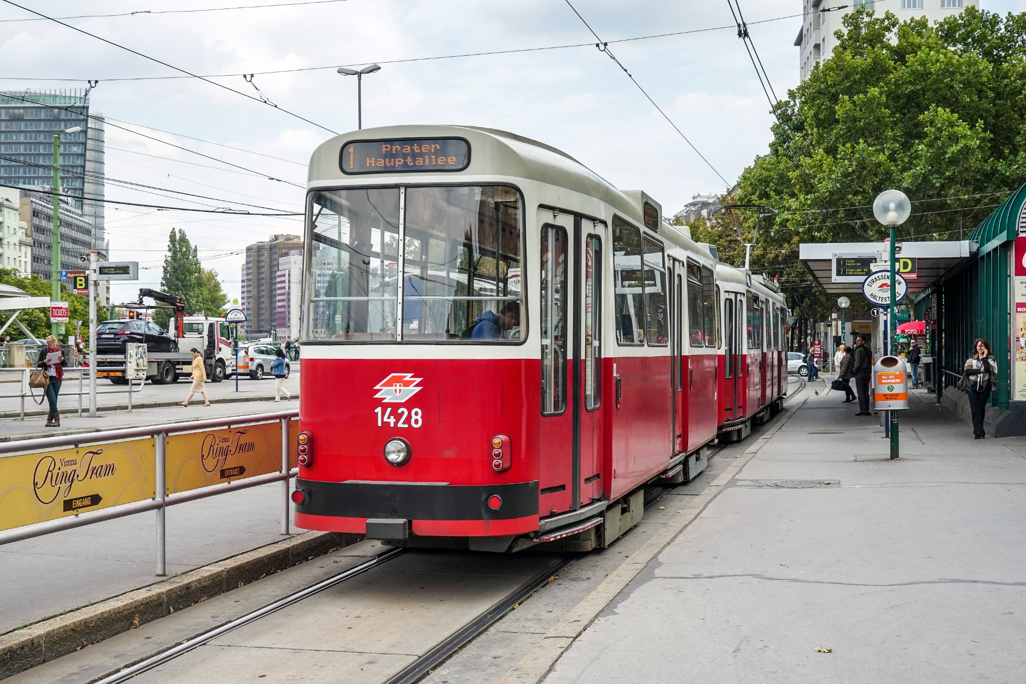 Street scene in Vienna showing a red public tram at Praterstern, with its destination display pointing toward Prater Hauptallee.
